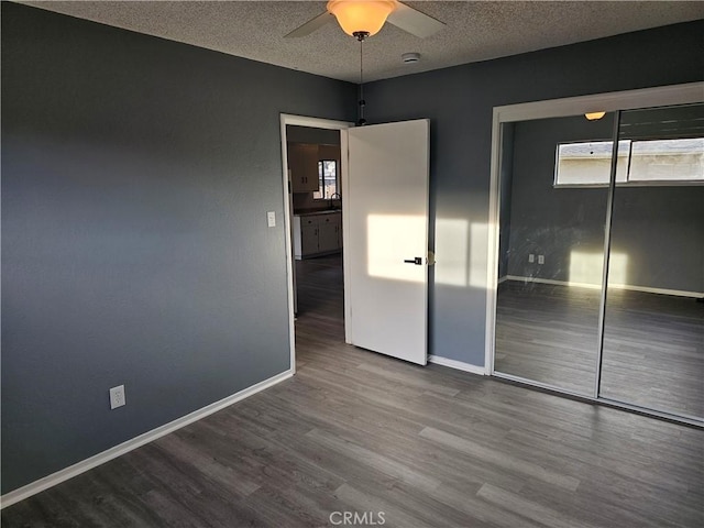 unfurnished bedroom with hardwood / wood-style flooring, a textured ceiling, ceiling fan, and a closet