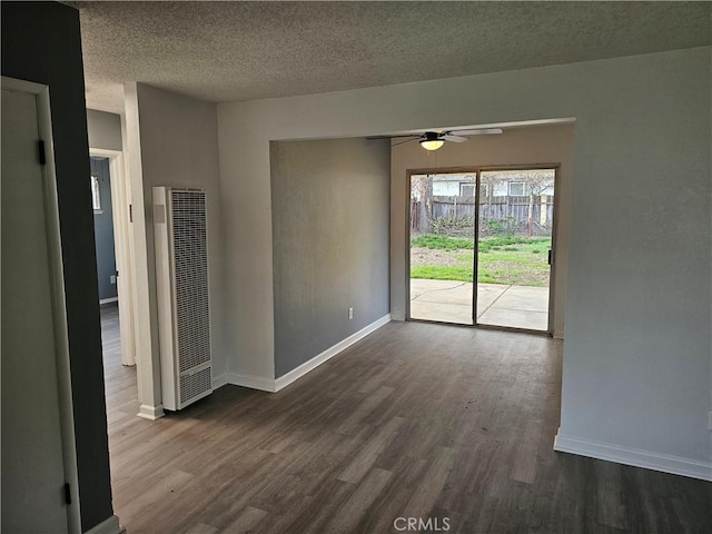 empty room featuring ceiling fan, dark hardwood / wood-style floors, and a textured ceiling