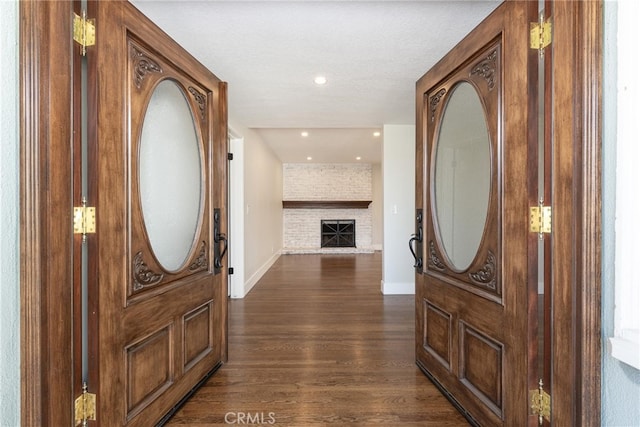 foyer entrance with a fireplace and dark hardwood / wood-style floors