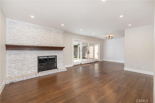 unfurnished living room featuring dark hardwood / wood-style flooring, a fireplace, and french doors