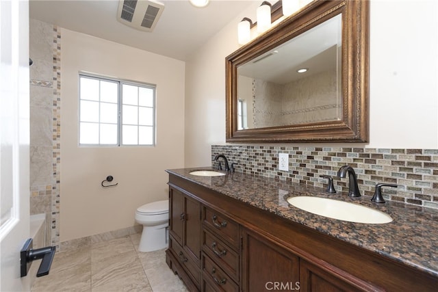 bathroom featuring tasteful backsplash, vanity, and toilet