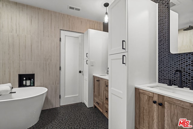 bathroom with vanity, tile walls, and a bathtub