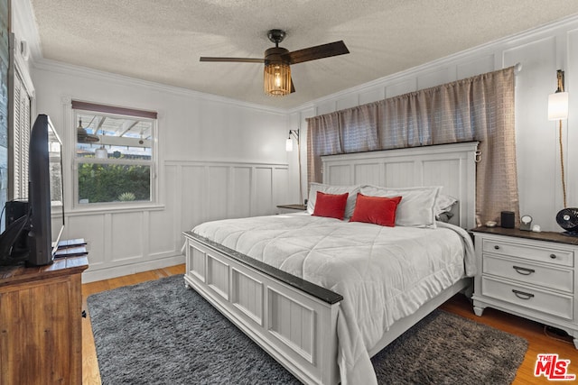 bedroom featuring ornamental molding, dark hardwood / wood-style flooring, and a textured ceiling