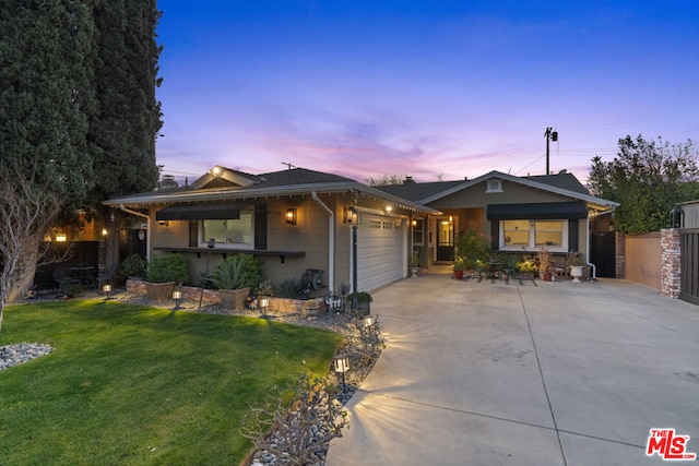 view of front of property featuring a garage and a lawn