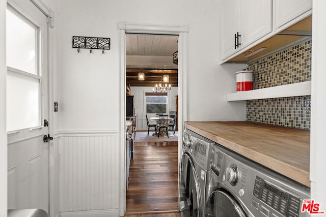 clothes washing area with cabinets, washing machine and dryer, plenty of natural light, and dark hardwood / wood-style flooring