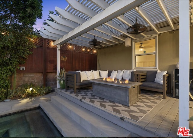 patio terrace at dusk with an outdoor living space with a fire pit and a pergola