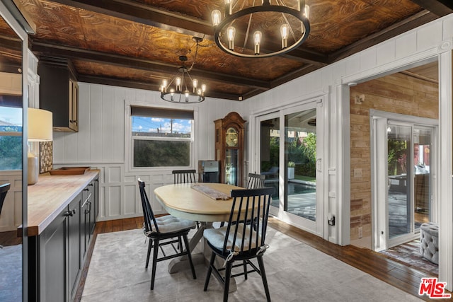 dining space with a notable chandelier, plenty of natural light, and hardwood / wood-style floors