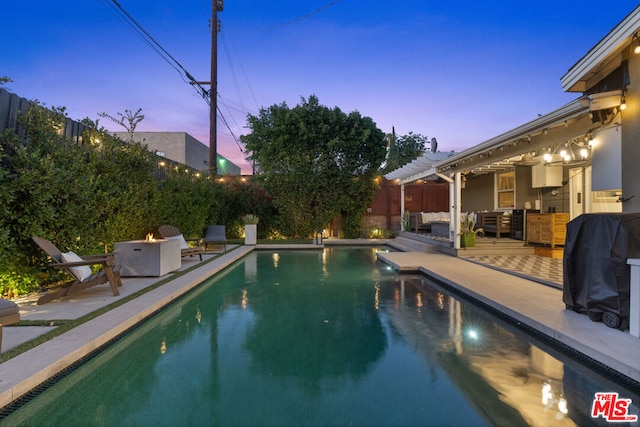 pool at dusk with an outdoor hangout area and a patio area