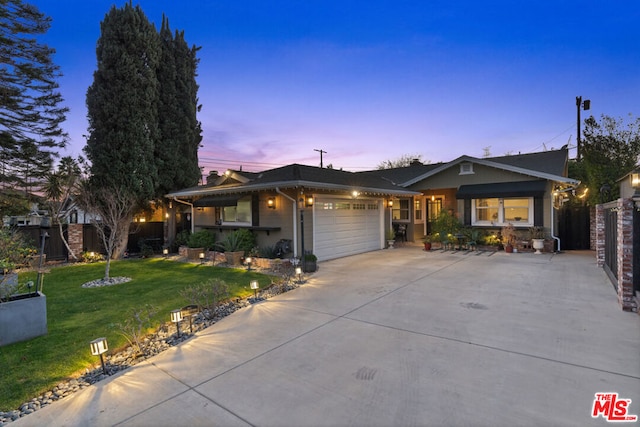 view of front of home featuring a garage and a lawn