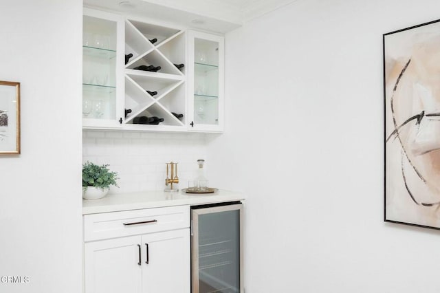 bar with decorative backsplash, beverage cooler, and white cabinets