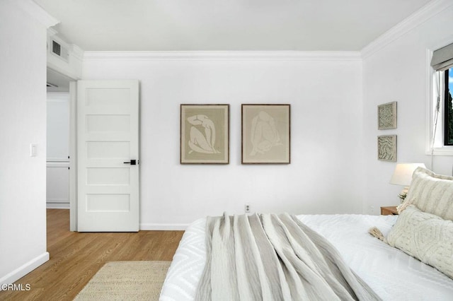 bedroom with hardwood / wood-style floors and ornamental molding