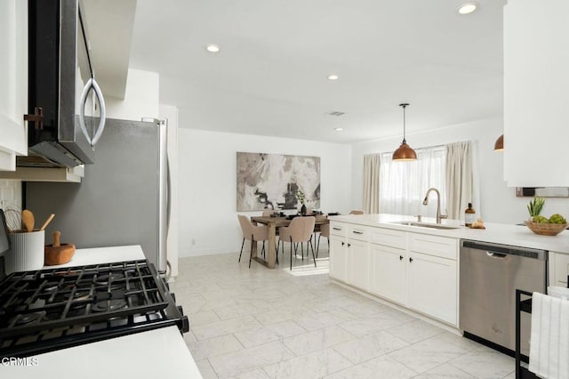 kitchen featuring pendant lighting, white cabinetry, appliances with stainless steel finishes, and sink