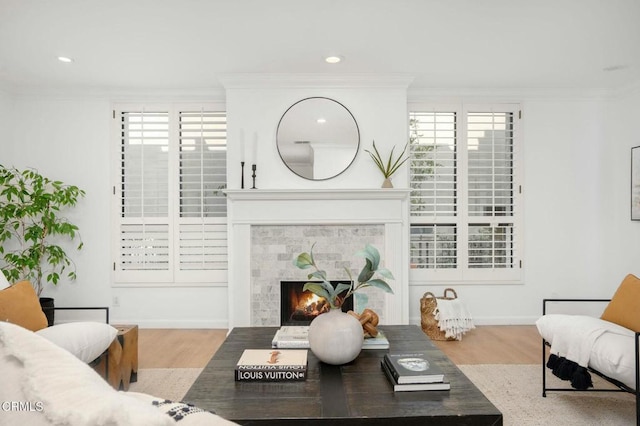 living room with hardwood / wood-style flooring, a tiled fireplace, and plenty of natural light