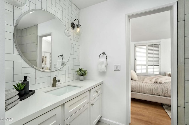 bathroom featuring wood-type flooring, vanity, and backsplash