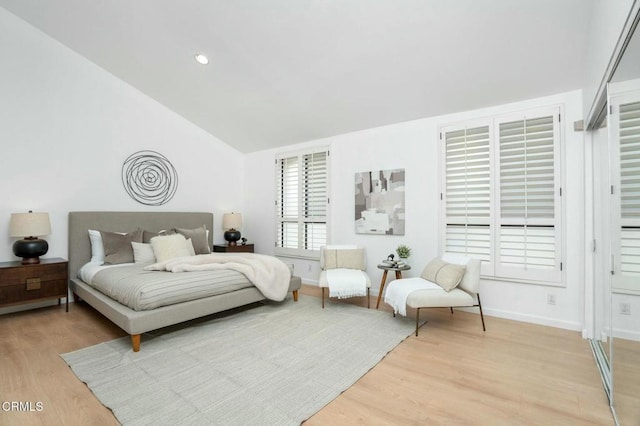 bedroom featuring lofted ceiling and light hardwood / wood-style flooring