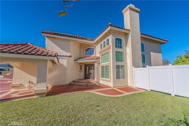 rear view of house with a yard and a patio