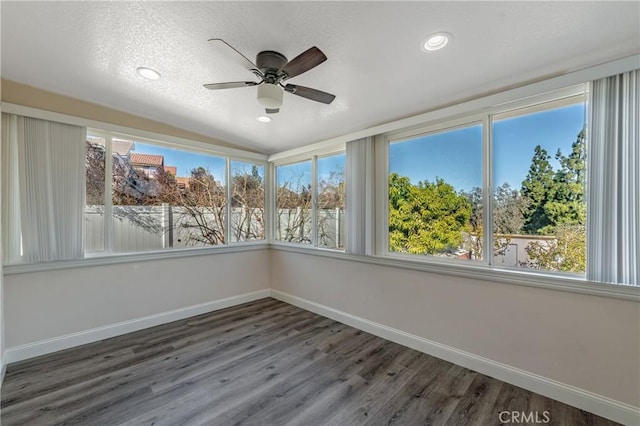 unfurnished sunroom with ceiling fan