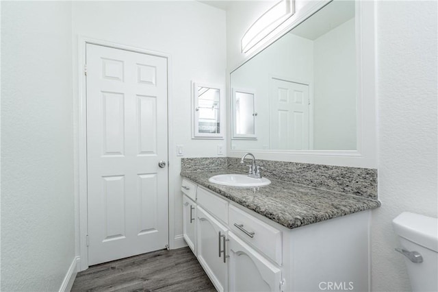 bathroom featuring vanity, toilet, and wood-type flooring