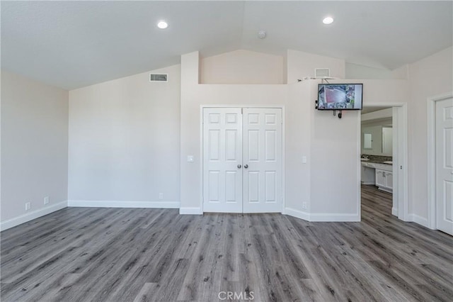 interior space featuring lofted ceiling and light hardwood / wood-style flooring