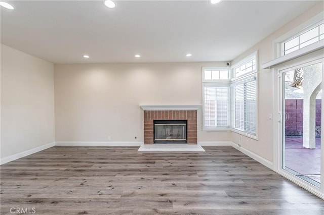 unfurnished living room with a brick fireplace and wood-type flooring