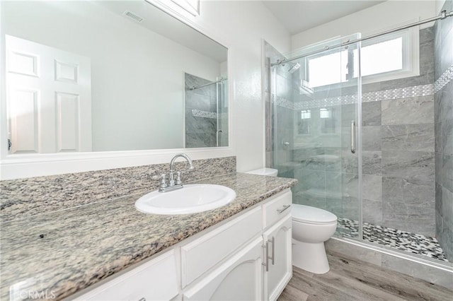 bathroom with vanity, an enclosed shower, wood-type flooring, and toilet