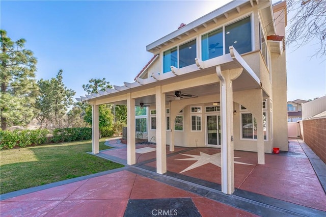 back of house featuring a yard, ceiling fan, and a patio area