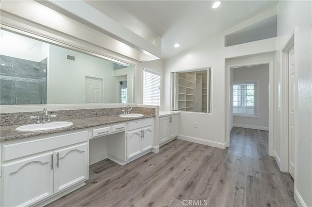 bathroom featuring vaulted ceiling, wood-type flooring, an enclosed shower, and vanity