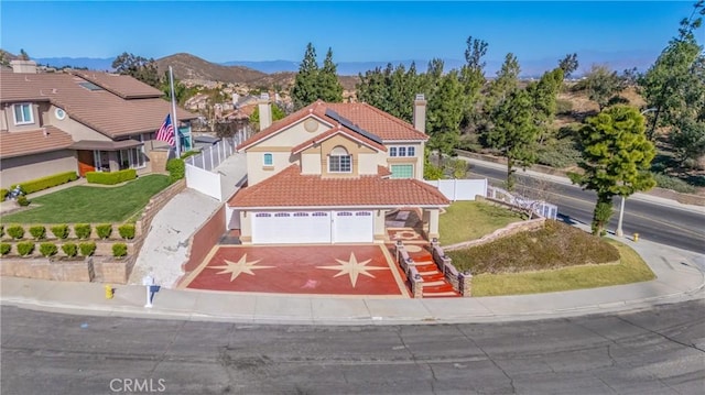 view of front of home featuring a garage, a mountain view, and a front yard