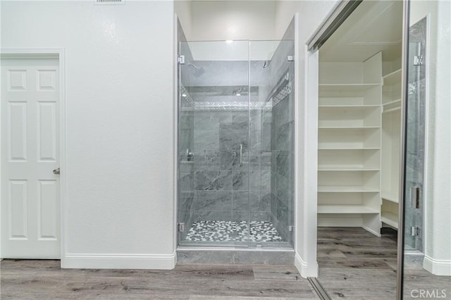 bathroom with hardwood / wood-style floors and walk in shower