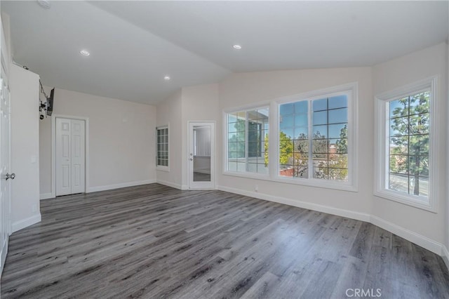 empty room featuring vaulted ceiling and dark wood-type flooring