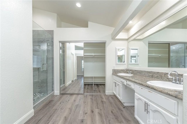 bathroom with vanity, wood-type flooring, lofted ceiling, and walk in shower