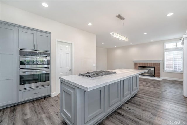 kitchen with hanging light fixtures, appliances with stainless steel finishes, and gray cabinetry