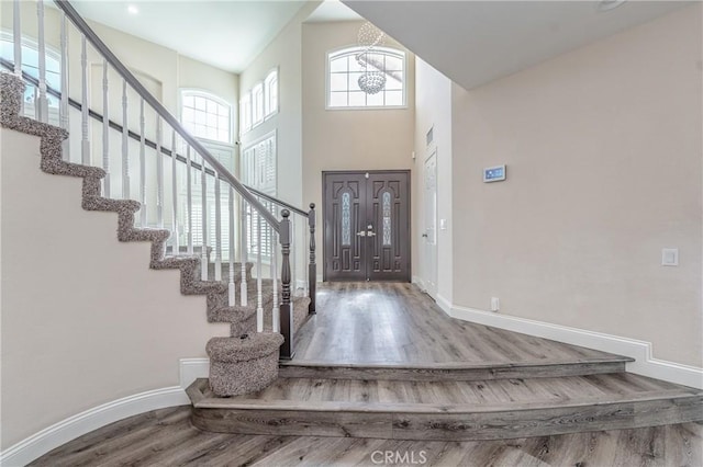 entryway with a towering ceiling and hardwood / wood-style floors