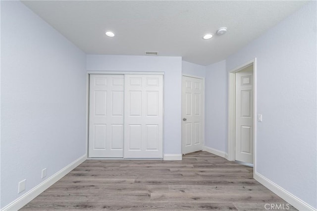 unfurnished bedroom with a closet and light hardwood / wood-style flooring