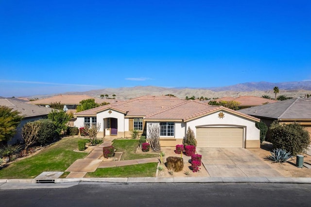 ranch-style home featuring a garage, a mountain view, and a front lawn