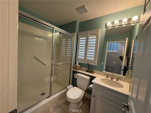 bathroom featuring vanity, an enclosed shower, a textured ceiling, and toilet