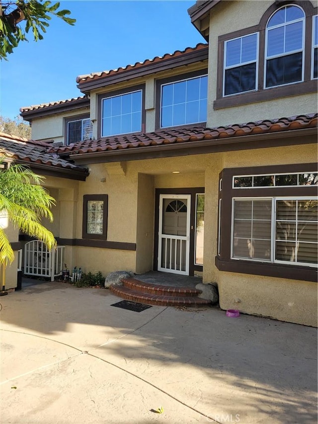 view of exterior entry featuring a patio