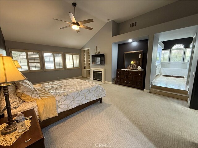 bedroom with light carpet, connected bathroom, lofted ceiling, and ceiling fan