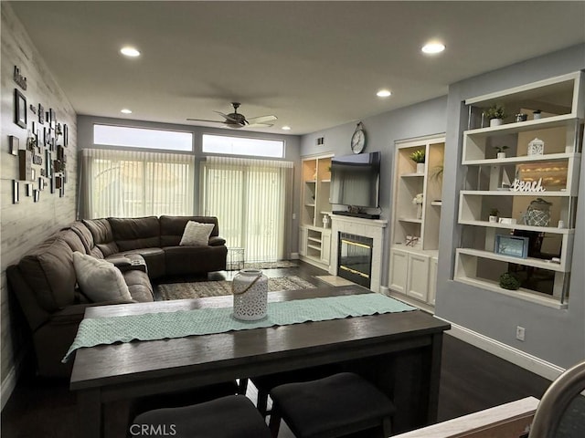 living room featuring ceiling fan, built in features, and dark hardwood / wood-style flooring