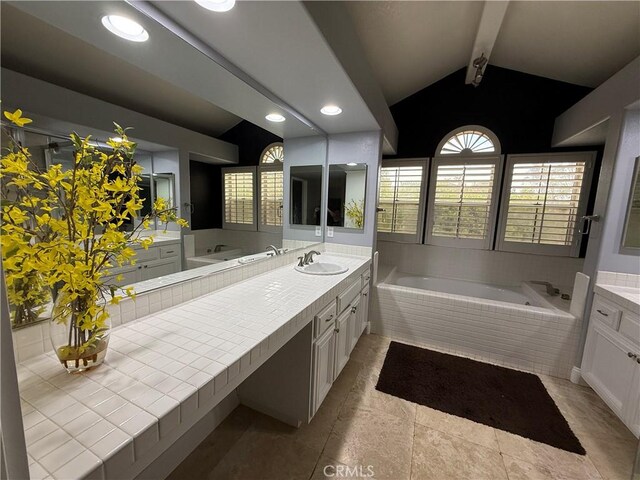 bathroom with vanity, vaulted ceiling with beams, a relaxing tiled tub, and tile patterned floors