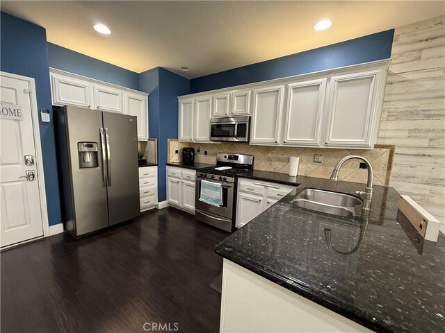 kitchen with white cabinetry, appliances with stainless steel finishes, sink, and backsplash