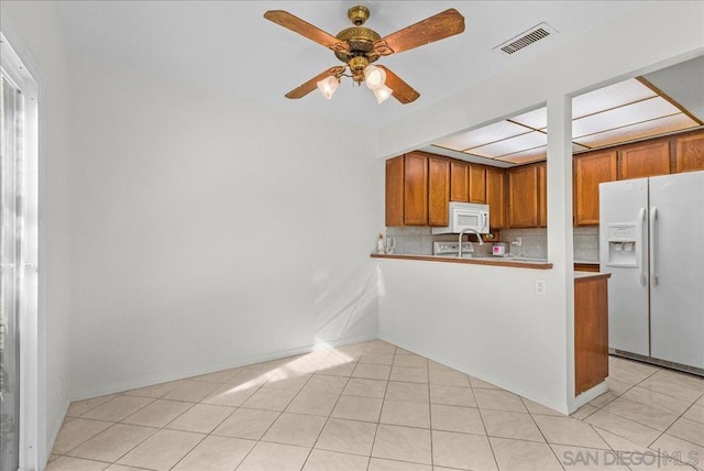 kitchen with white appliances, light tile patterned floors, kitchen peninsula, ceiling fan, and decorative backsplash