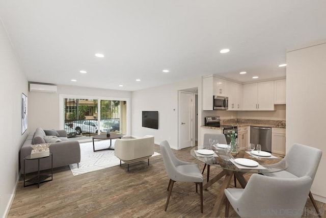 dining space with wood-type flooring and a wall mounted AC