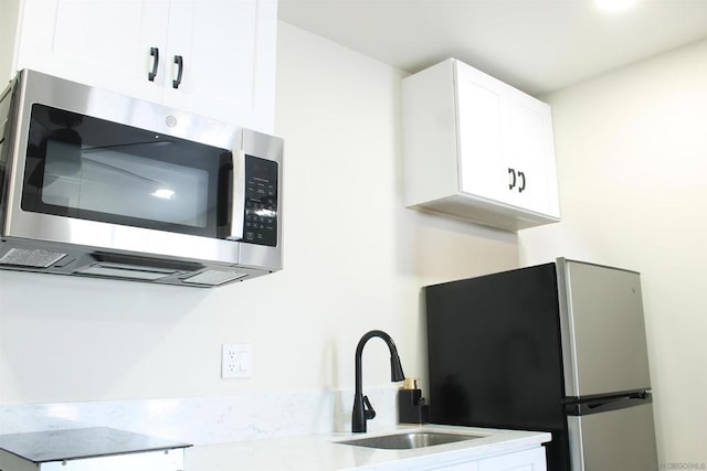 kitchen with white cabinetry, sink, and stainless steel appliances