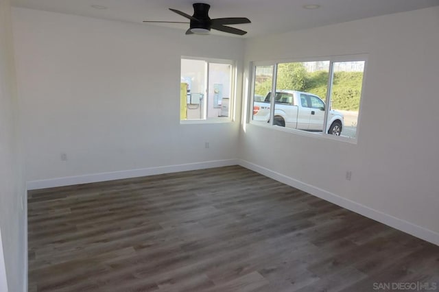 empty room featuring dark wood-type flooring and ceiling fan