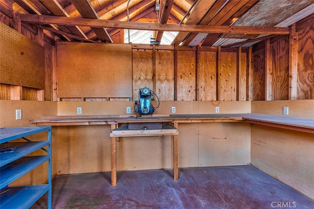 interior space with lofted ceiling, unfinished concrete floors, and a workshop area