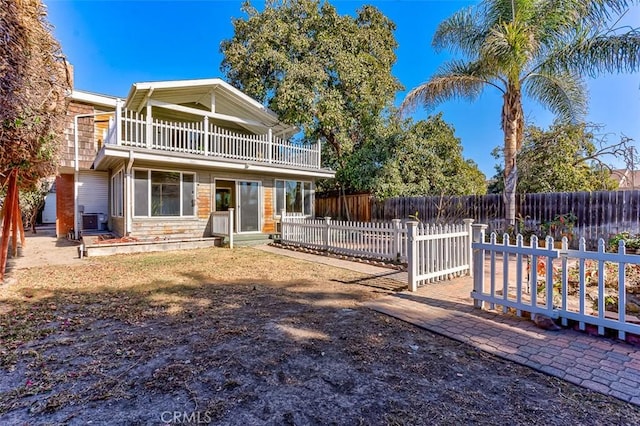 view of front of home featuring fence private yard and a balcony