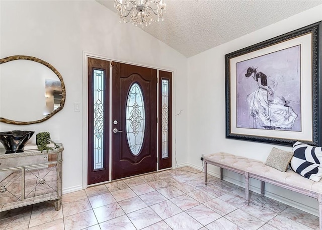 entryway featuring a textured ceiling, baseboards, marble finish floor, an inviting chandelier, and vaulted ceiling