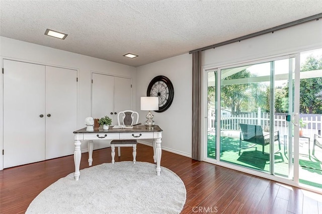 home office with a textured ceiling and wood finished floors