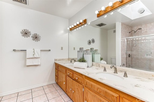 full bathroom featuring toilet, a sink, tile patterned floors, visible vents, and a shower stall